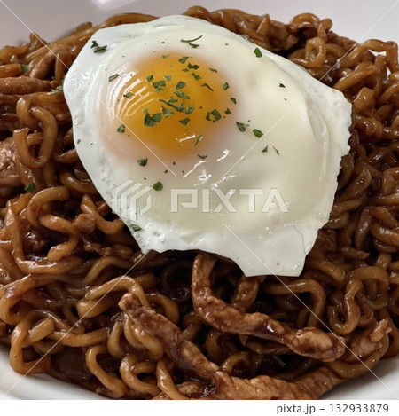 Savory jjapagetti noodles with a rich black bean sauce, topped with green onions and sesame seeds. A comforting Korean favorite that combines depth and flavor in each bite. 132933879