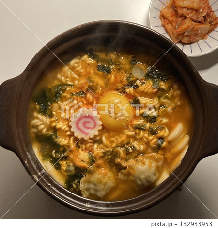 Steaming hot ramyun with rich, savory broth and chewy noodles, paired with spicy, tangy kimchi. A perfect Korean comfort food combination, balancing bold flavors and satisfying textures. 132933953