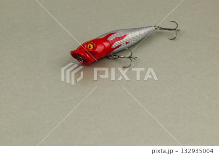 Colorful fishing lure resting on a smooth surface indoors Colorful fishing lure resting on a smooth surface indoors 132935004