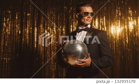 Man in tux with disco ball on gold backdrop, created AI 132935170