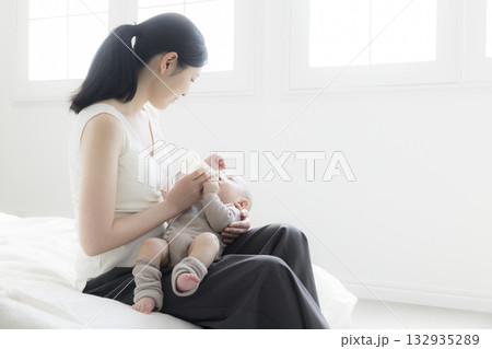 赤ちゃんにミルクをあげる母親 赤ちゃんにミルクをあげる母親 132935289