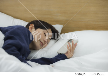 ベッドでスマホを見る女性 132935366