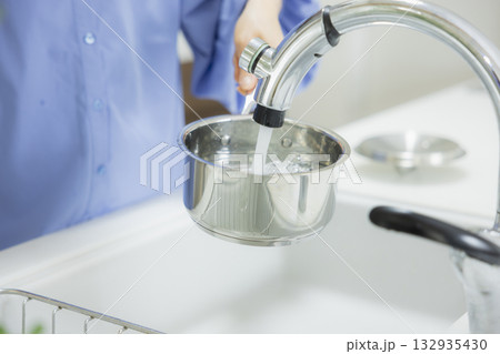 キッチンで鍋に水を入れる女性 132935430
