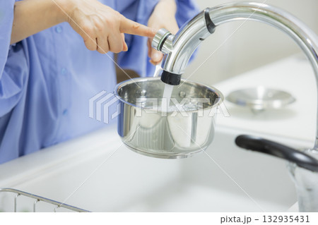 キッチンで鍋に水を入れる女性 キッチンで鍋に水を入れる女性 132935431