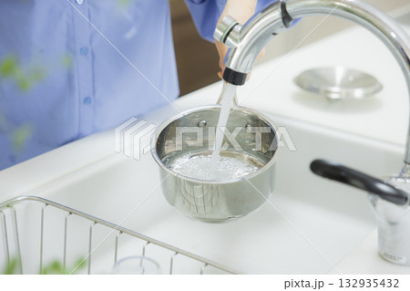 キッチンで鍋に水を入れる女性 132935432