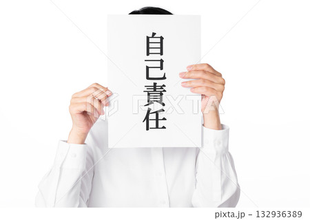 自己責任と書かれた紙を持つ白いシャツを着た人物 132936389