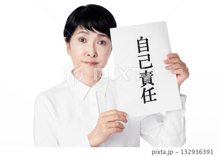 自己責任と書かれた紙を持ちカメラ目線のシニア女性 自己責任と書かれた紙を持ちカメラ目線のシニア女性 132936391