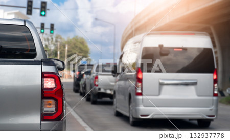 Rear side of silver pickup car with turn on brake light. Prepare to drive from traffic lgiht green color. Many cars are lined up ready to drive. Side of road with cement bridge under blue sky. Rear side of silver pickup car with turn on brake light. Prepare to drive from traffic lgiht green color. Many cars are lined up ready to drive. Side of road with cement bridge under blue sky. 132937778