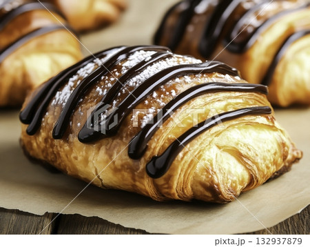 Freshly Baked Chocolate Croissant with Drizzled Chocolate Sauce Freshly Baked Chocolate Croissant with Drizzled Chocolate Sauce 132937879