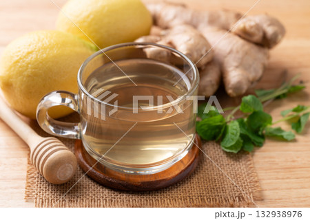 Lemon and ginger tea in cup glass on wooden background, Healthy hot drink 132938976