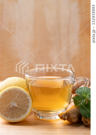 Lemon and ginger tea in cup glass with mint leaf, Healthy hot drink Lemon and ginger tea in cup glass with mint leaf, Healthy hot drink 132938993