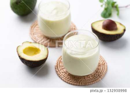 Avocado smoothie with milk in glass and avocado fruit on white background, Healthy drink 132938998