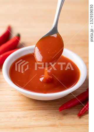 Sriracha sauce in a bowl with spoon on wooden background, Chili sauce 132939030