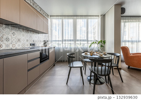 Modern Kitchen with Patterned Tiles and Tea Set by Large Windows Modern Kitchen with Patterned Tiles and Tea Set by Large Windows 132939630