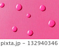 Pink water drops on a pink background. Top view, flat lay. 132940346