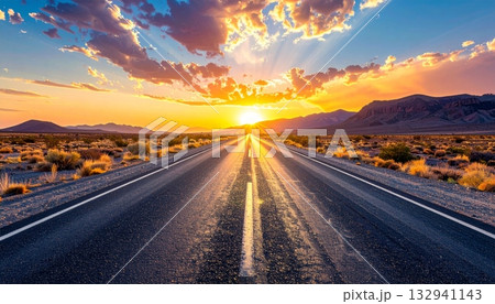 Empty desert highway stretches toward the fiery sunset horizon, symbolizing freedom and the long journey ahead beneath the vibrant sky 132941143