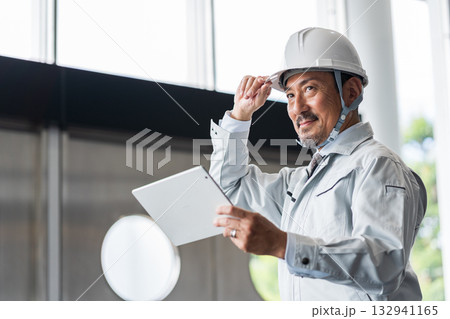 タブレットを見る現場監督のミドル男性。 132941165