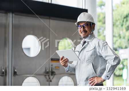 タブレットを見る現場監督のミドル男性。 132941169