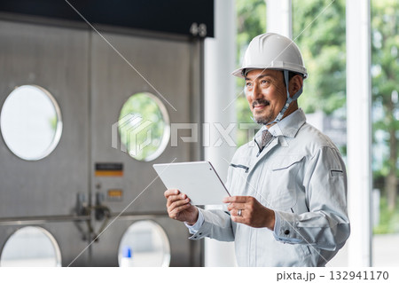 タブレットを見る現場監督のミドル男性。 タブレットを見る現場監督のミドル男性。 132941170