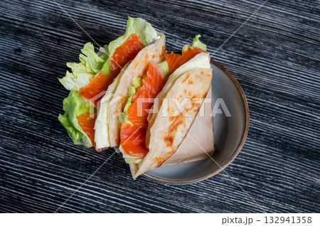 Homemade salmon flatbread on a table in a cafe. Homemade salmon flatbread on a table in a cafe. 132941358