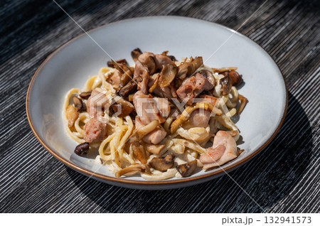 Plate of chicken and mushroom pasta.  132941573