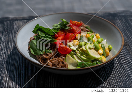 Top view of a dish of buckwheat noodles with vegetables.  132941592