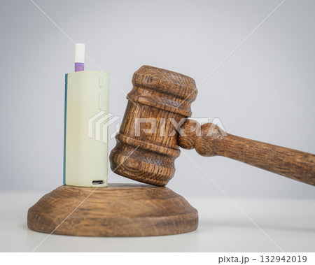 Judge's gavel and e-cigarette. Smoking ban. Tobacco heating systems. Judge's gavel and e-cigarette. Smoking ban. Tobacco heating systems. 132942019