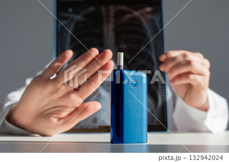Doctor holding x-ray of lungs with e-cigarette in background. Doctor holding x-ray of lungs with e-cigarette in background. 132942024