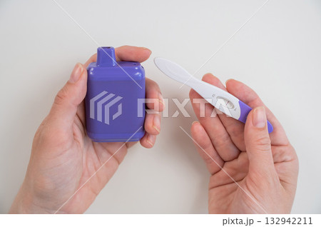 Woman holding pregnancy test and e-cigarette. Woman holding pregnancy test and e-cigarette. 132942211