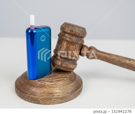 Judge's gavel and e-cigarette. Smoking ban. Tobacco heating systems. Judge's gavel and e-cigarette. Smoking ban. Tobacco heating systems. 132942276