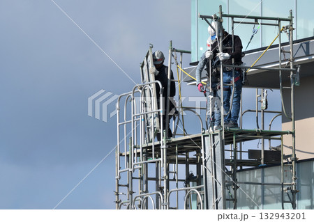 工事現場 新築マンション 仮設足場の解体作業風景 工事現場 新築マンション 仮設足場の解体作業風景 132943201