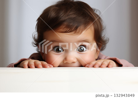 baby peeking over the edge with big eyes. 132943849