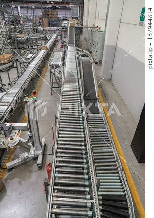 packing line in a logistics warehouse. conveyor belt in a modern production line packing line in a logistics warehouse. conveyor belt in a modern production line 132944814