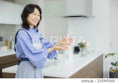 キッチンで水を飲む女性  132945082