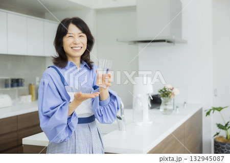 キッチンで水を飲む女性  132945087