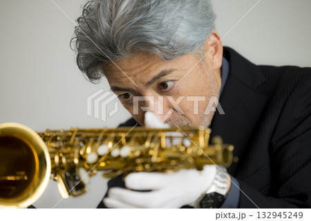 サックスをメンテナンスするシニア男性   132945249