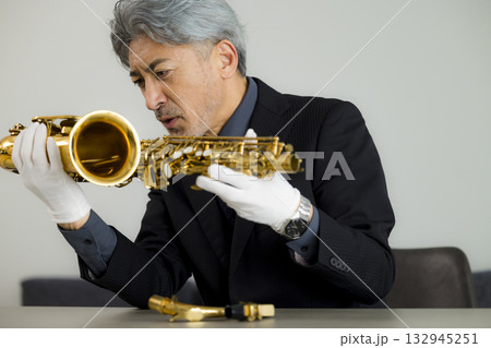 サックスをメンテナンスするシニア男性   132945251