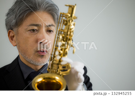 サックスをメンテナンスするシニア男性   132945255