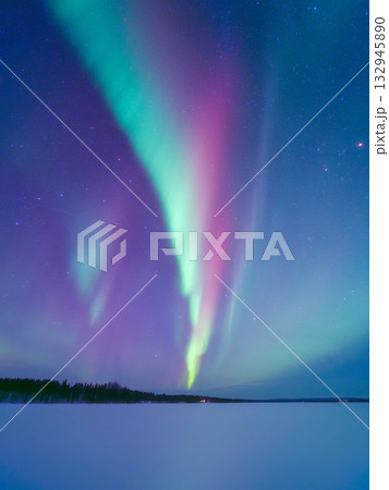 Aurora Borealis in Scandinavia. Northern lights over frozen lake. Starry sky. Glow on the sky. 132945890