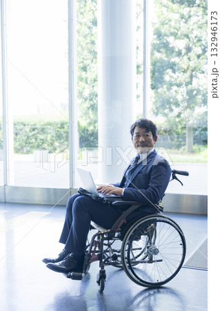 車椅子に乗るスーツの男性 132946173