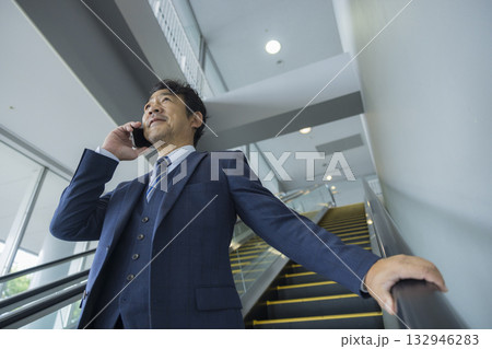 エスカレーターに乗るビジネスマン 132946283