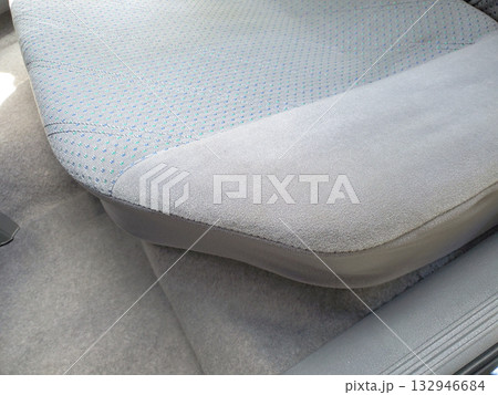 Close-up of rear seat in 1990s sedan, featuring soft grey upholstery with subtle blue dotted fabric pattern. The interior design typical of vintage cars, illustrating automotive retro interiors 90s 132946684