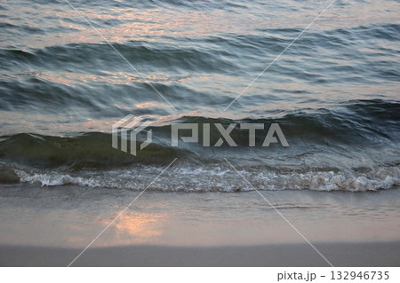 Sea wave washing sandy beach at sunset 132946735