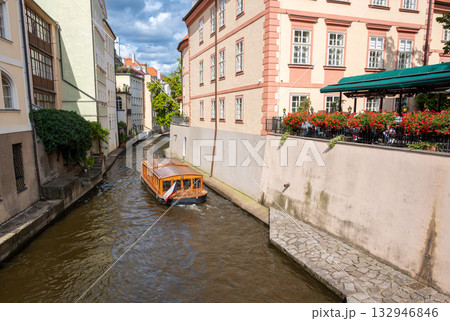 Prague, Czech Republic, August 8, 2023. Shot at Kampa Island with the Certovka River in Old Prague. A tourist boat travels along the canal. Travel destinations. Prague, Czech Republic, August 8, 2023. Shot at Kampa Island with the Certovka River in Old Prague. A tourist boat travels along the canal. Travel destinations. 132946846