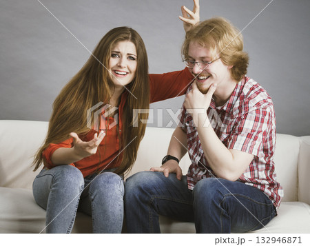 Happy man and woman sitting on sofa 132946871