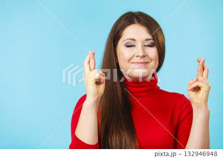Woman keeping her fingers crossed Woman keeping her fingers crossed 132946948