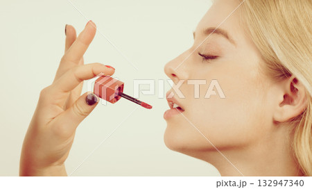 Woman applying lipstick or lip gloss Woman applying lipstick or lip gloss 132947340