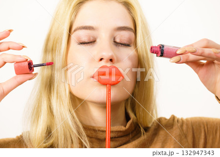 Woman applying lipstick or lip gloss Woman applying lipstick or lip gloss 132947343
