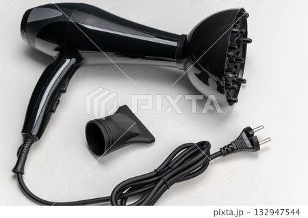 Black hair dryer with diffuser attachment and power cord, showcasing sleek design and functionality for hairstyling, ideal for personal grooming and professional use Black hair dryer with diffuser attachment and power cord, showcasing sleek design and functionality for hairstyling, ideal for personal grooming and professional use 132947544