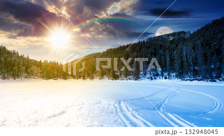 winter landscape with snow covered ground. day and night time change concept. frozen lake among spruce forest with sun and moon. panoramic view of winter wonderland. duality and transition template winter landscape with snow covered ground. day and night time change concept. frozen lake among spruce forest with sun and moon. panoramic view of winter wonderland. duality and transition template 132948045